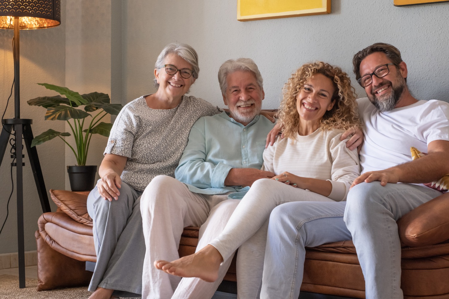 Senior parents relaxing on the sofa with their adult children